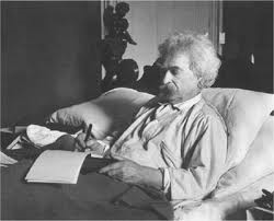 Mark Twain writing in bed